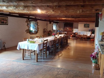 Grande pièce commune avec table familiale, idéale pour partager des repas entre amis ou en famille dans le Cantal