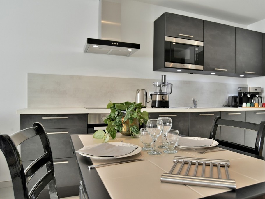 Cuisine parfaitement équipée pour la préparation des vos petits déjeuners et repas. Table dressée en mode duo.