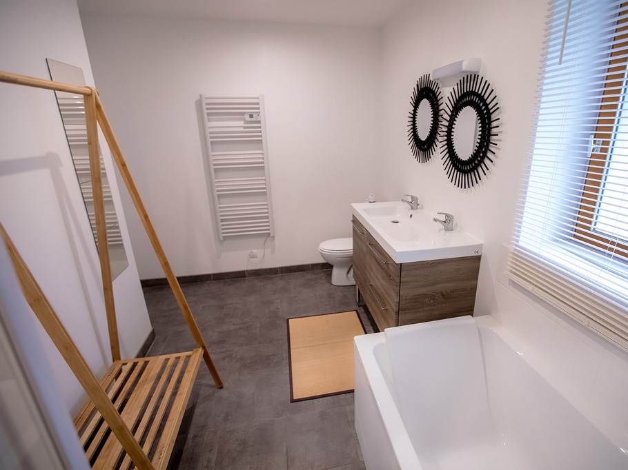 Salle de bains avec baignoire, douche et double vasques au RDC