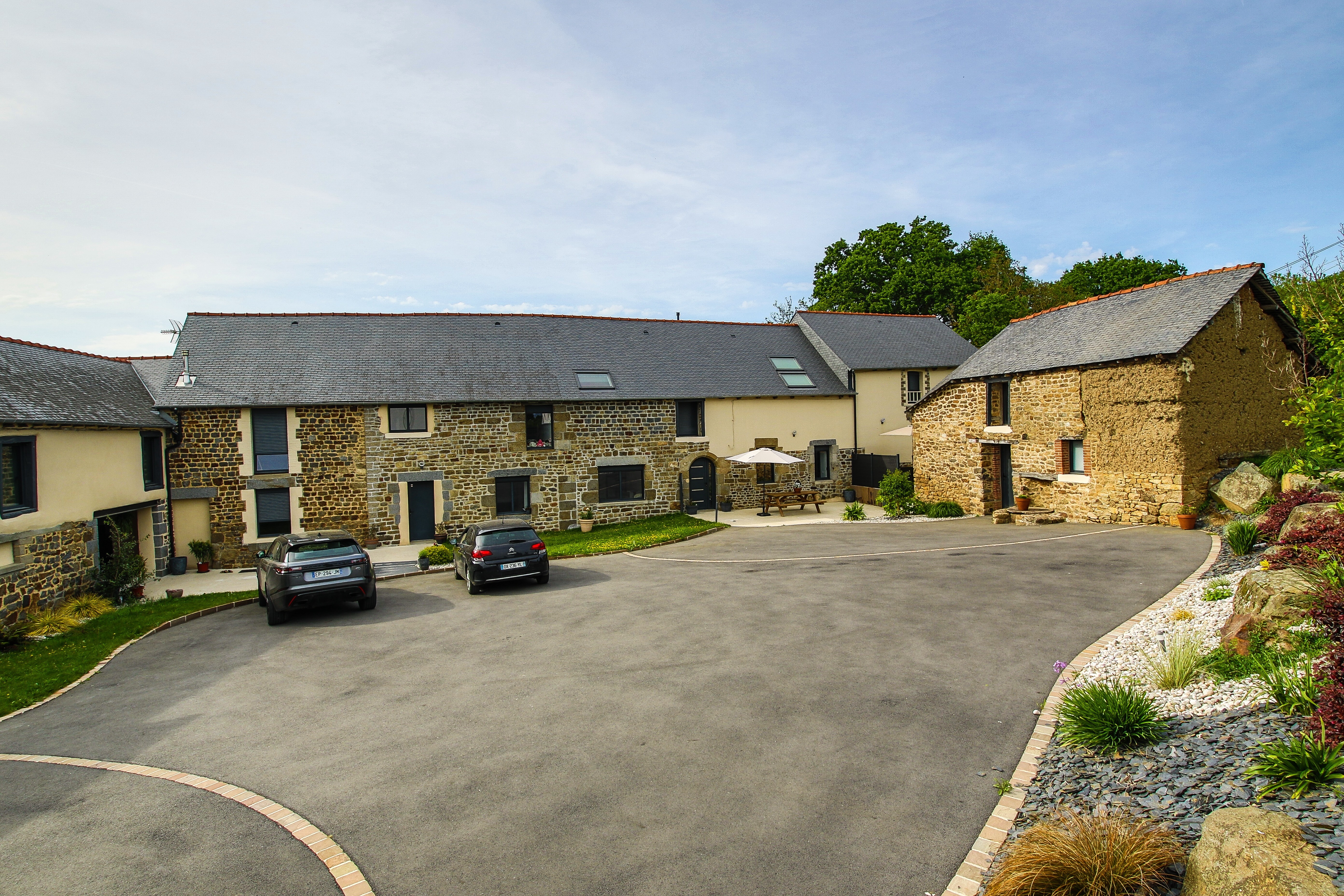 Façade de la longère rénovée.
A gauche se trouve le gîte "Songe" pouvant accueillir 6 personnes. 
La cour, l'espace pelouse et la salle de sport sont communs aux 2 gîtes.