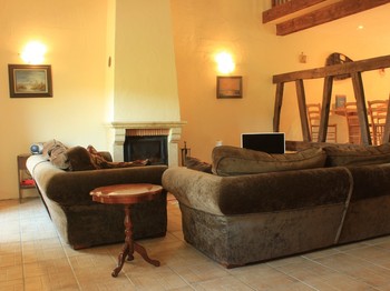 Spacieux salon et sa cheminée et ses poutres apparentes