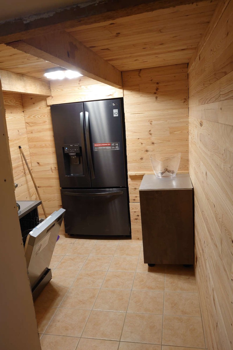 Arrière cuisine avec frigo américain et lave vaisselle. Lave linge