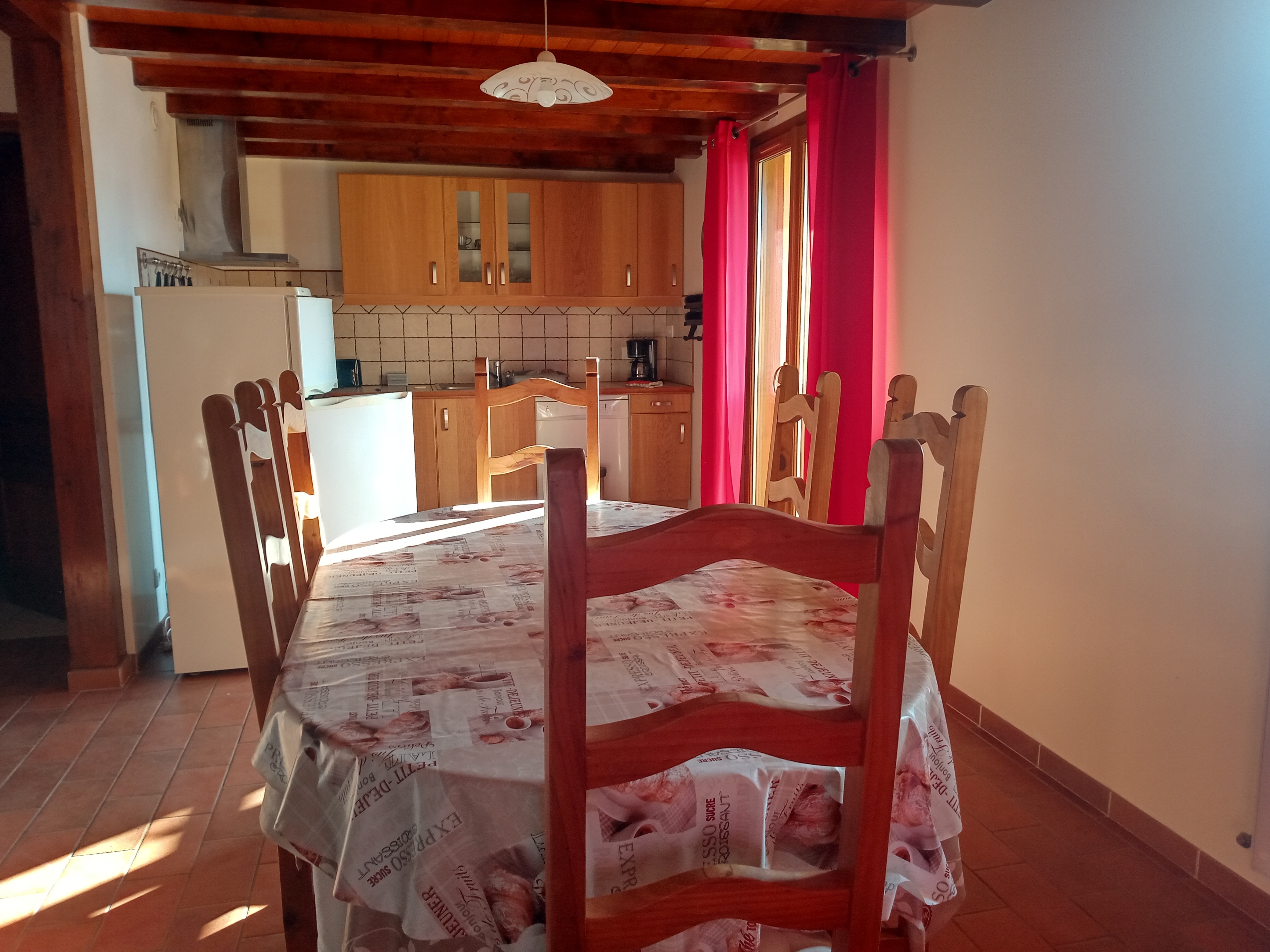 Vue d'ensemble cuisine équipée et table pour les repas