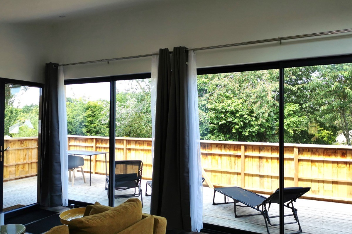 Vue de la terrasse en bas depuis l'intérieur de l'appartement. Vue sur les arbres.