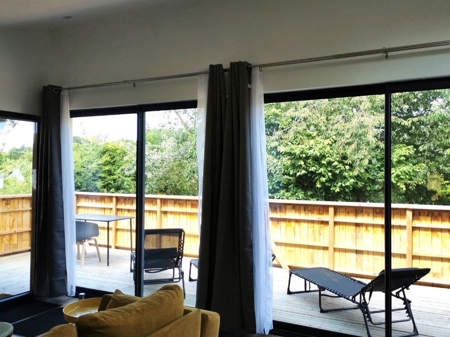 Vue de la terrasse en bas depuis l'intérieur de l'appartement. Vue sur les arbres.
