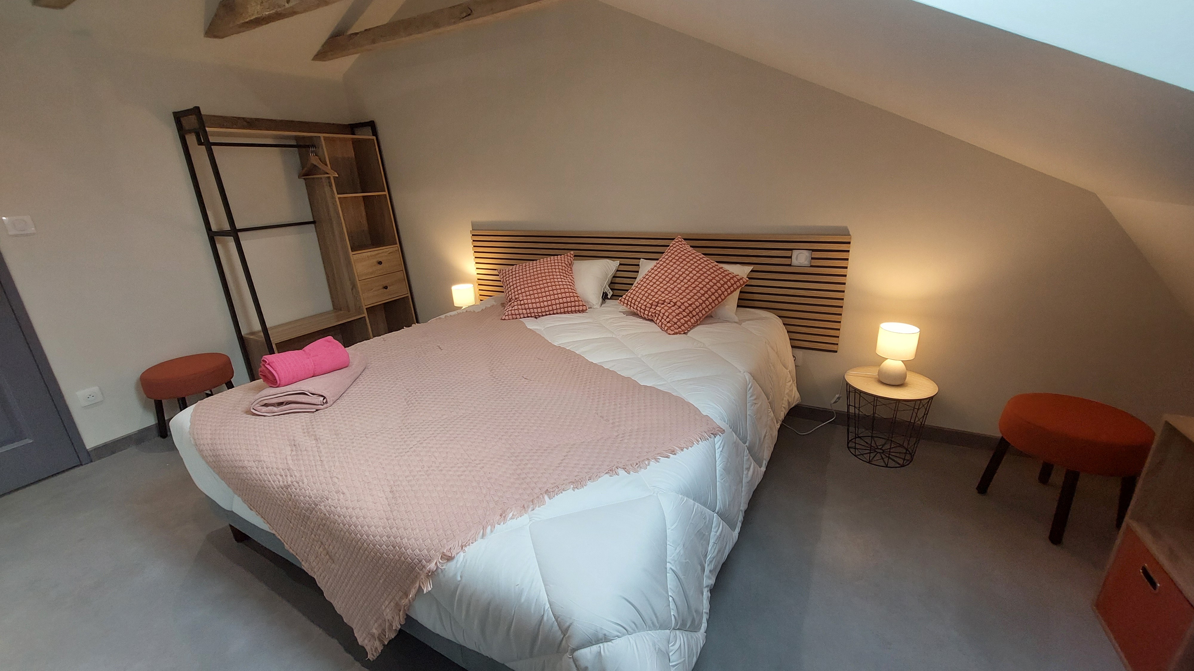 Chambre rose du gîte avec lit double modulable, ambiance chaleureuse et touches de décoration raffinées