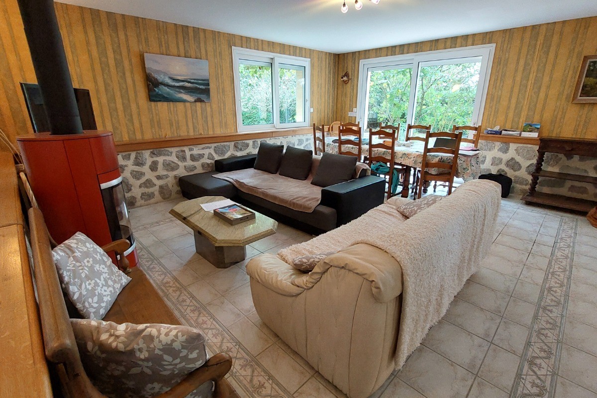 Spacieuse pièce de vie avec accès direct à la terrasse et vue sur le lac.
