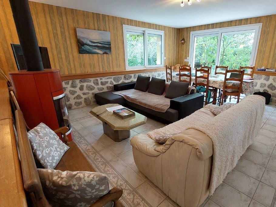 Spacieuse pièce de vie avec accès direct à la terrasse et vue sur le lac.