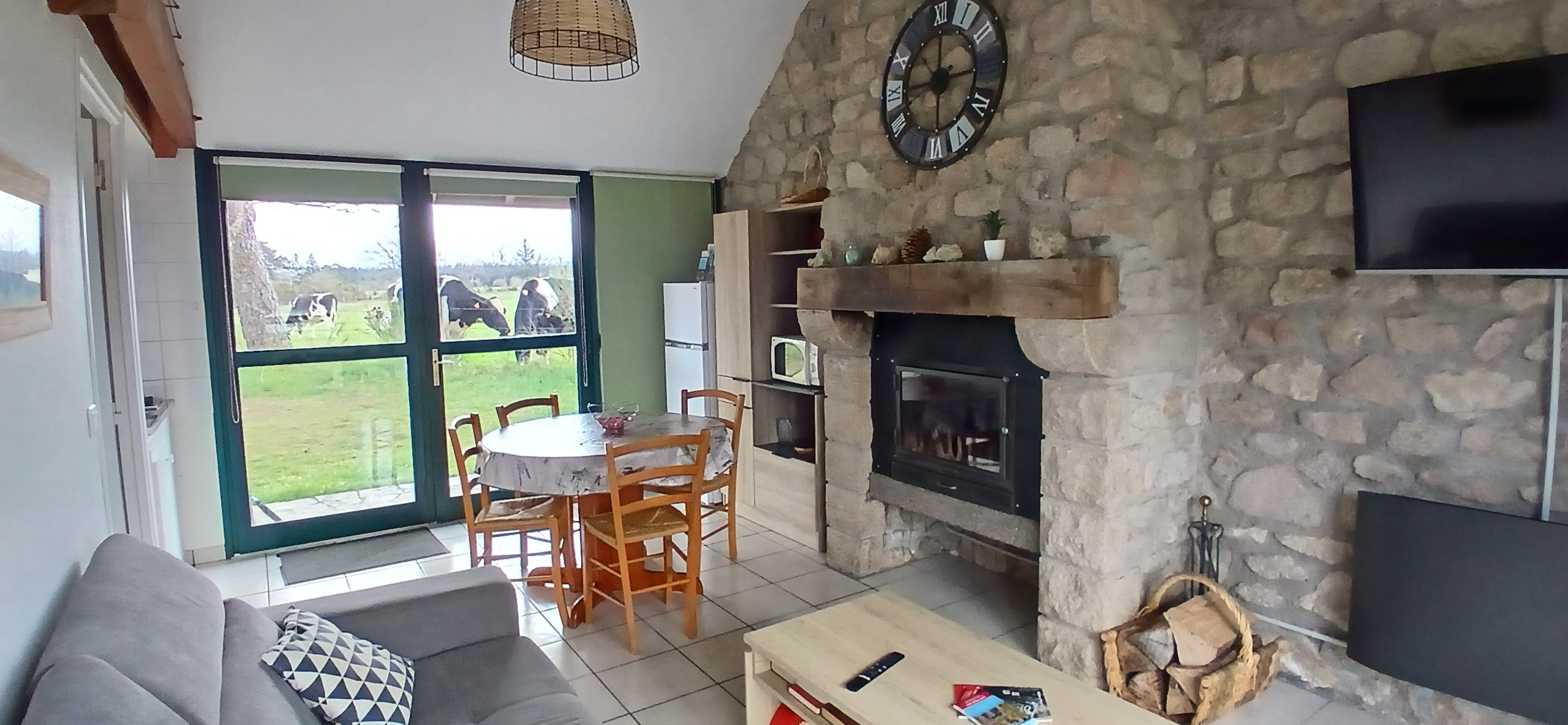 Etang de Farges, Saint Germain près Herment, Chalet vert - Pièce de vie avec cheminée et canapé convertible dans le salon