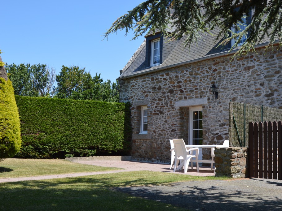 Agréable jardin de 600 m² avec terrasse et salon de jardin, transats, et barbecue.