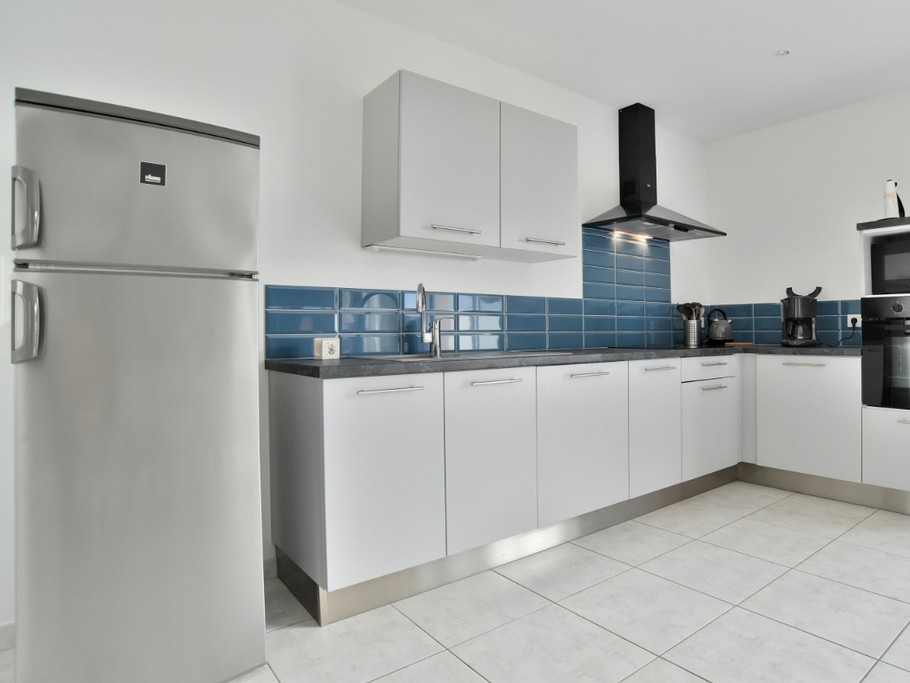 Grande pièce de vie avec coin cuisine, coin séjour et coin salon avec poêle à bois. Cuisine ouverte, aménagée et toute équipée.