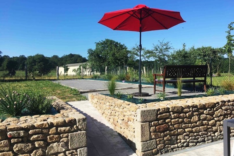 Dans le jardin, un boulodrome pour des parties de pétanque, un banc, une balançoire.