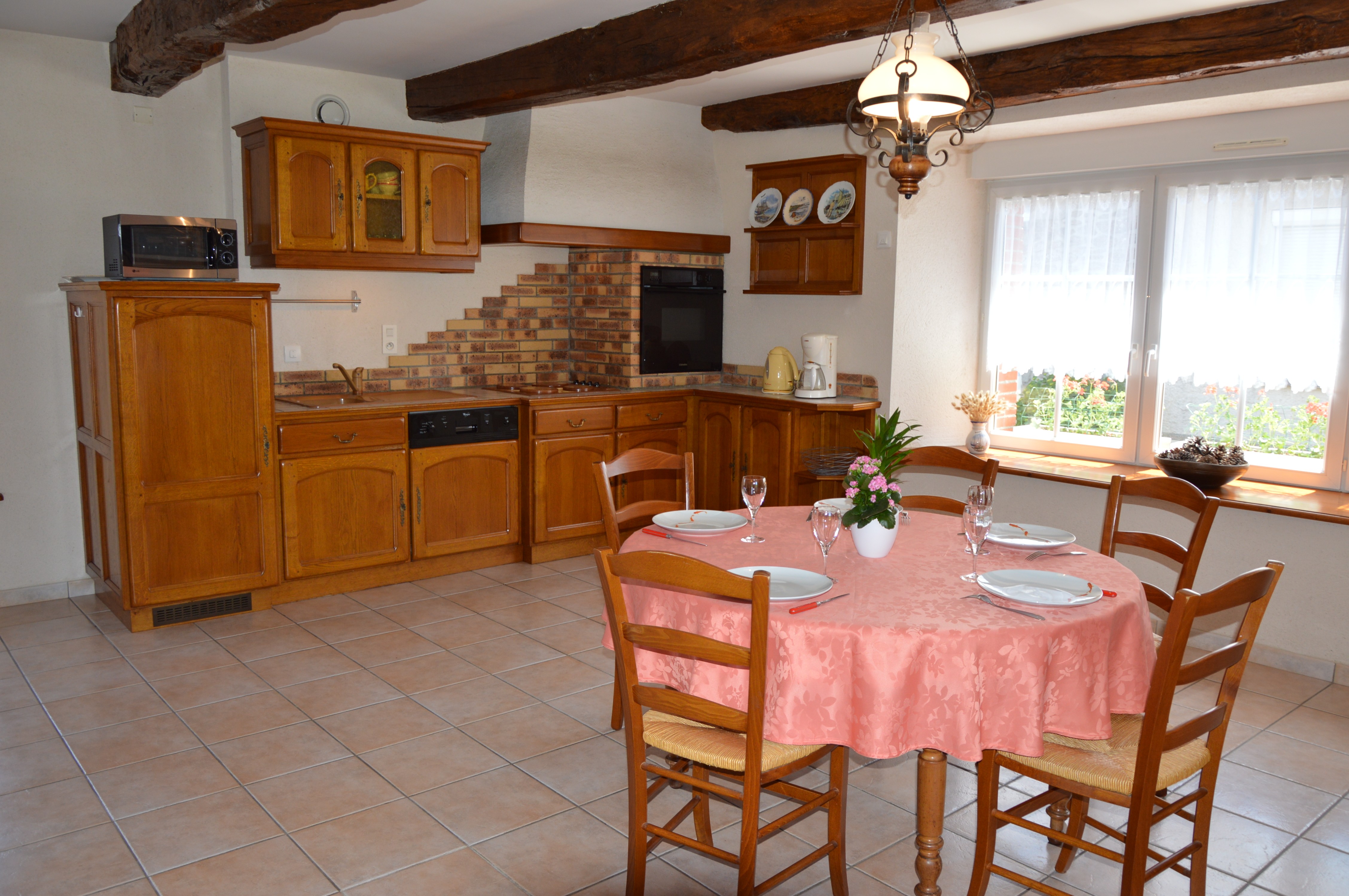 Pièce de vie agréable avec poutres apparente. Coin cuisine toute équipée avec table à manger