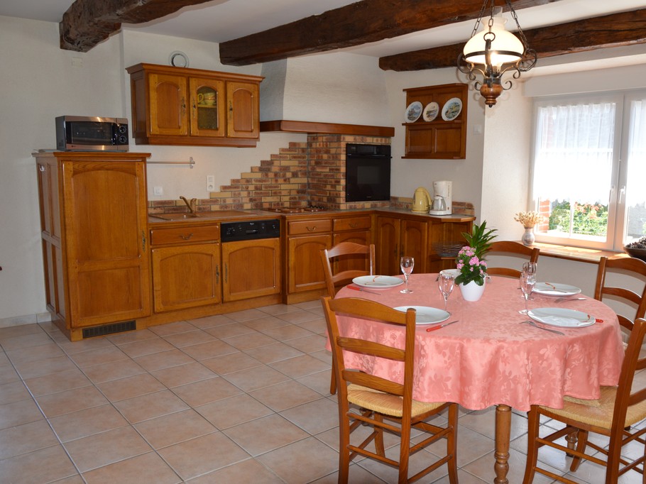 Pièce de vie agréable avec poutres apparente. Coin cuisine toute équipée avec table à manger