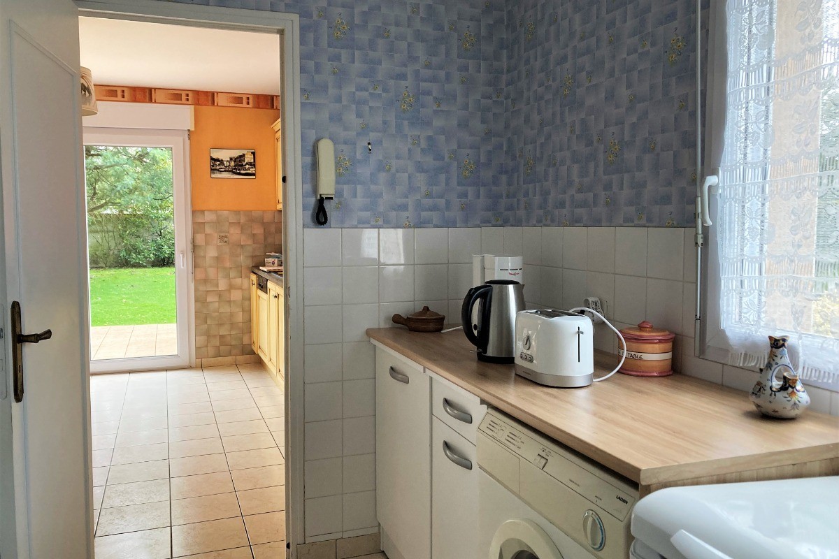Arrière-cuisine avec lave-linge et sèche-linge.