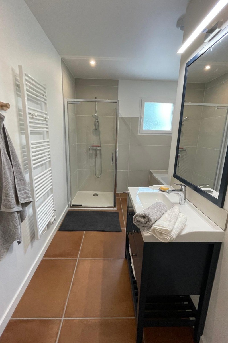 la salle de bain avec douche et baignoire