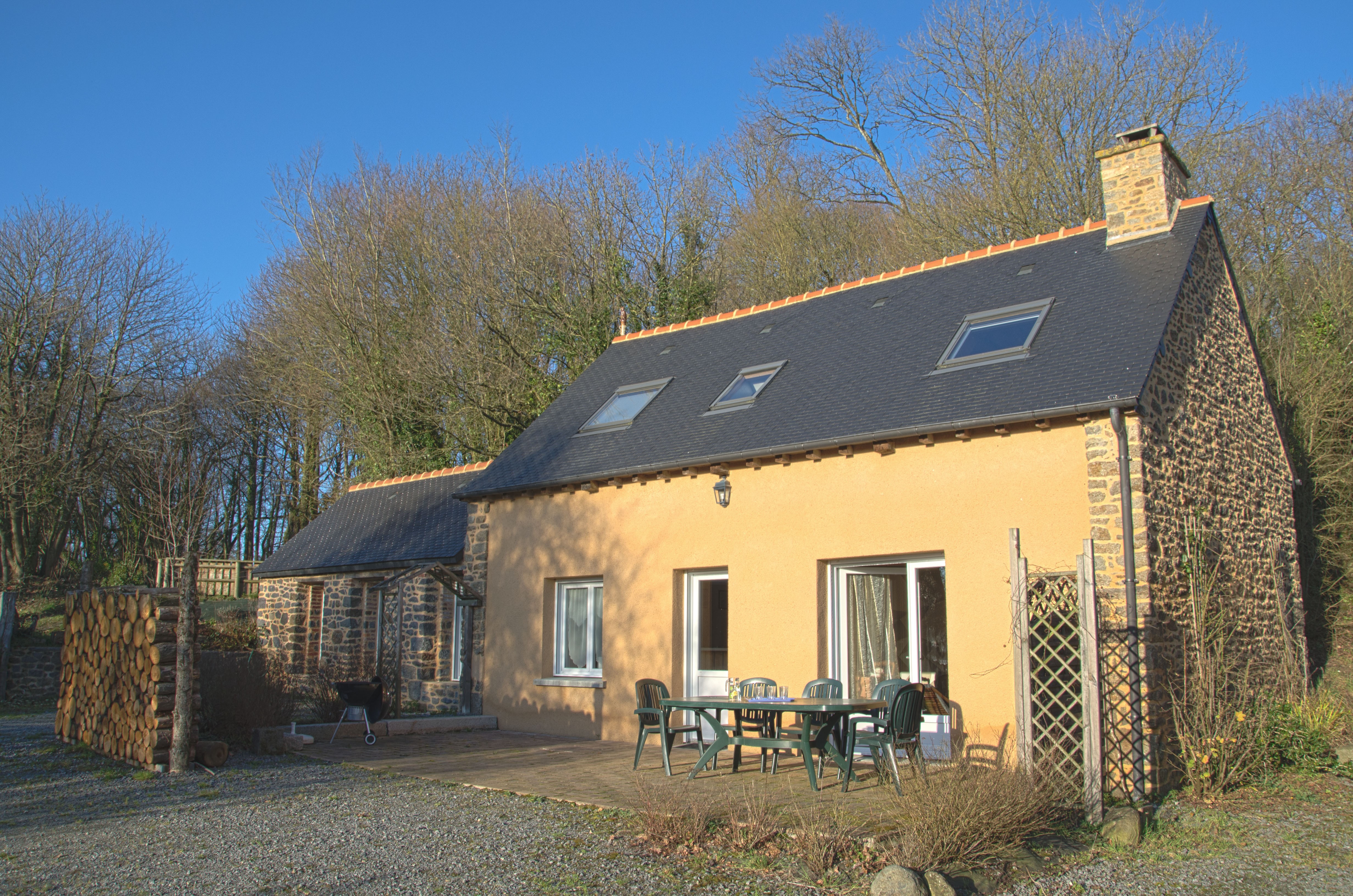 Façade de la maison avec la terrasse et la porte d'entrée.