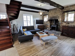 Salon avec TV et poêle à bois