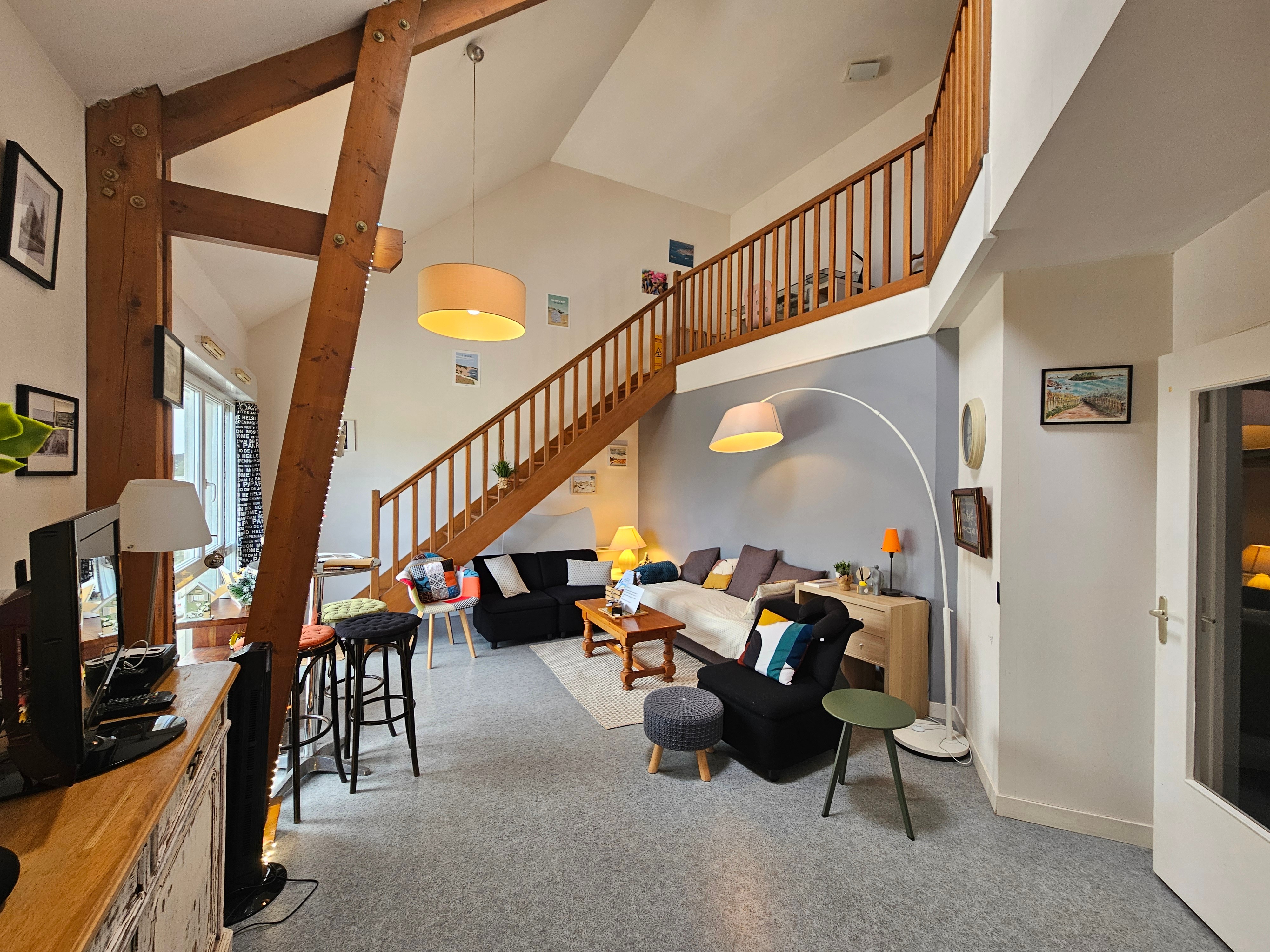 Pièce de vie très agréable, haute de plafond et lumineuse avec salon et bureau. Cuisine ouverte.