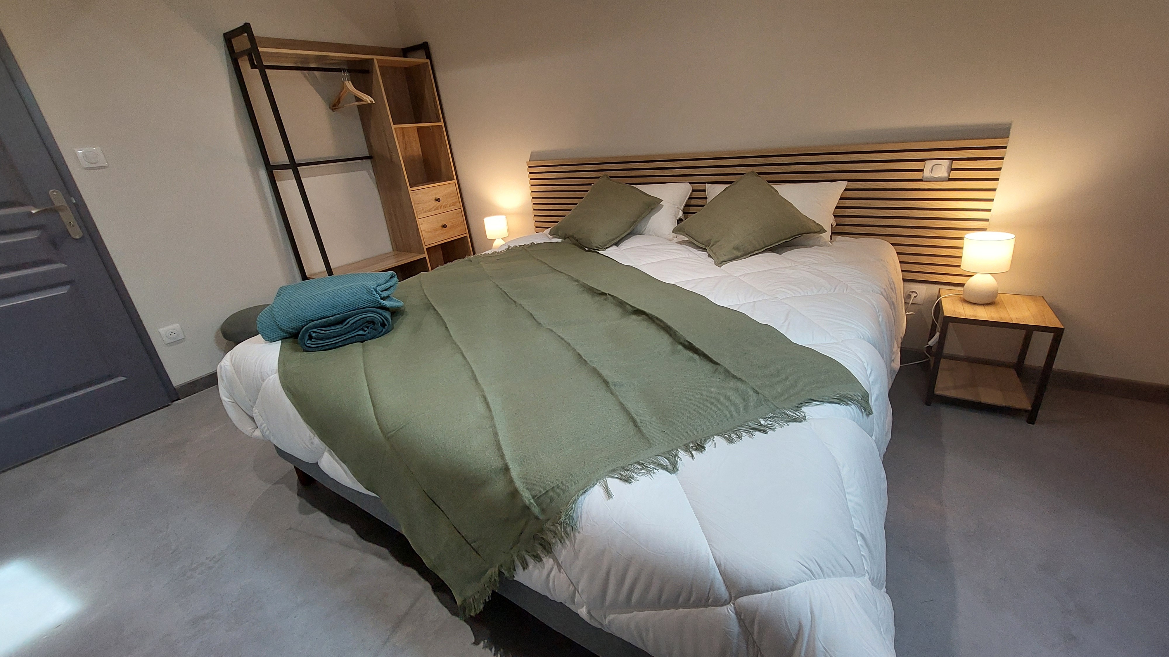 Chambre verte du gîte avec lit double modulable, couleurs apaisantes et grand espace de rangement