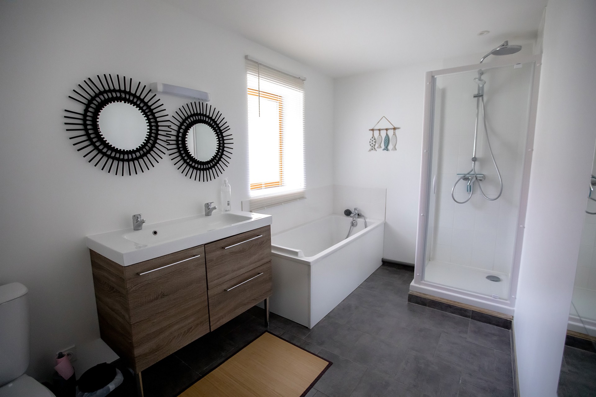 Salle de bains avec baignoire, douche et double vasques au RDC