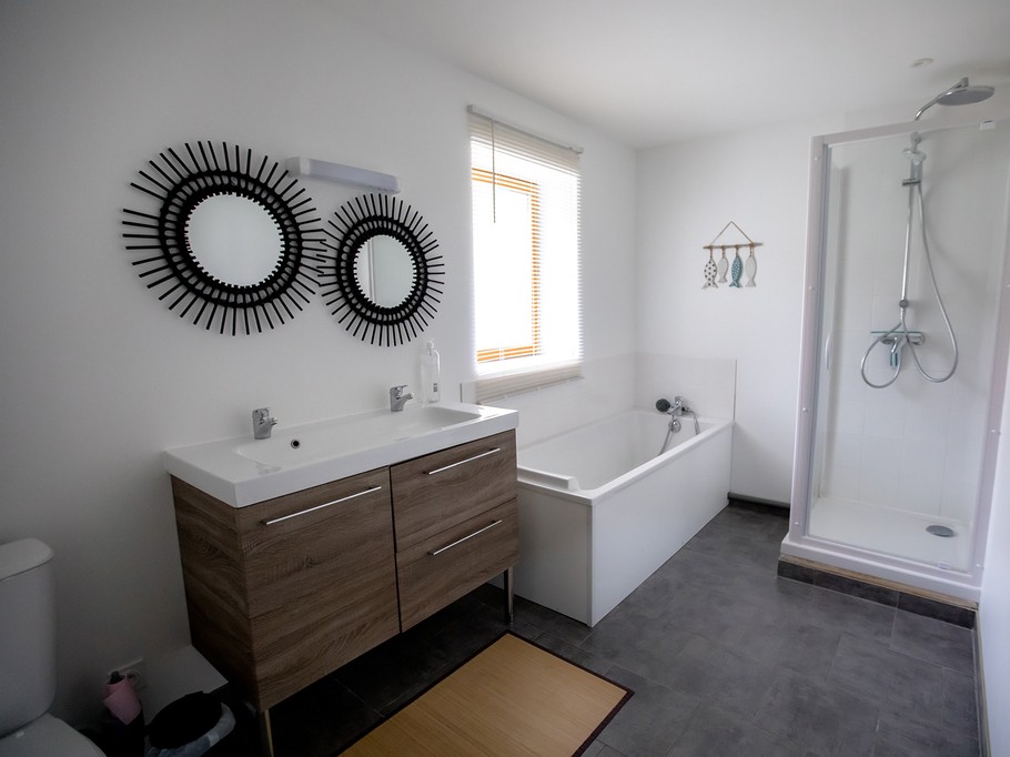 Salle de bains avec baignoire, douche et double vasques au RDC