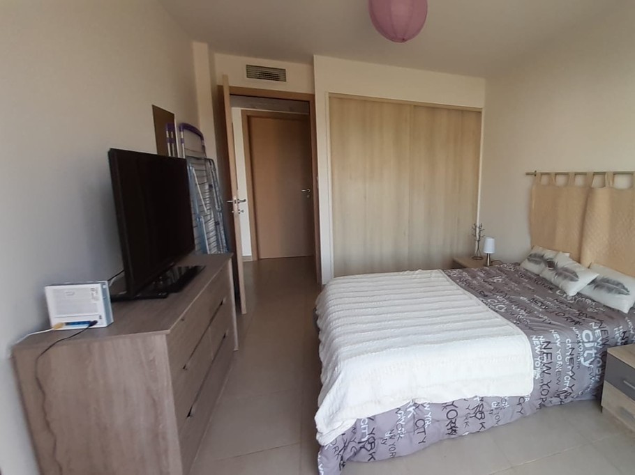 chambre avec commode, TV et grand placard dans le fond