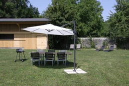 Jardin avec barbecue et chaises longues