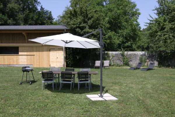 Jardin avec barbecue et chaises longues
