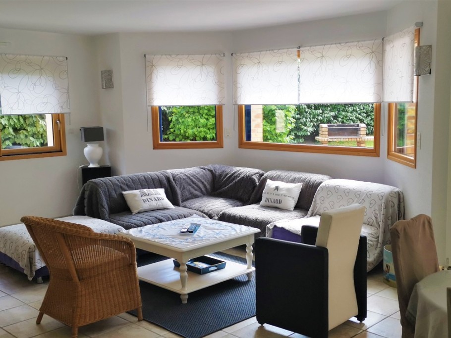 Grande pièce de vie lumineuse avec accès jardin. Coin salon.