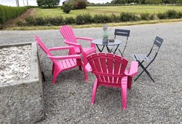 Petit salon de jardin dans la cour. Jardin derrière.