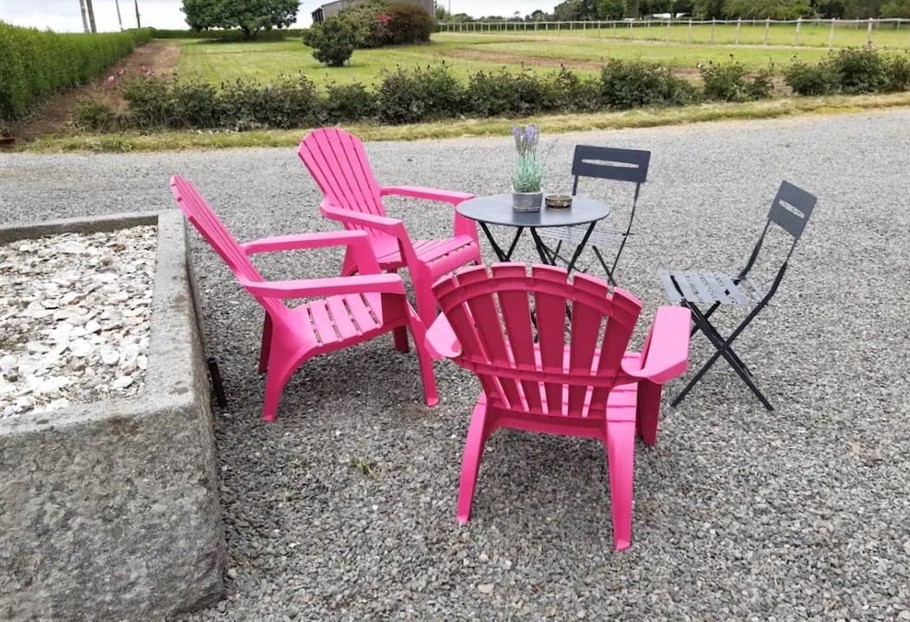 Petit salon de jardin dans la cour. Jardin derrière.