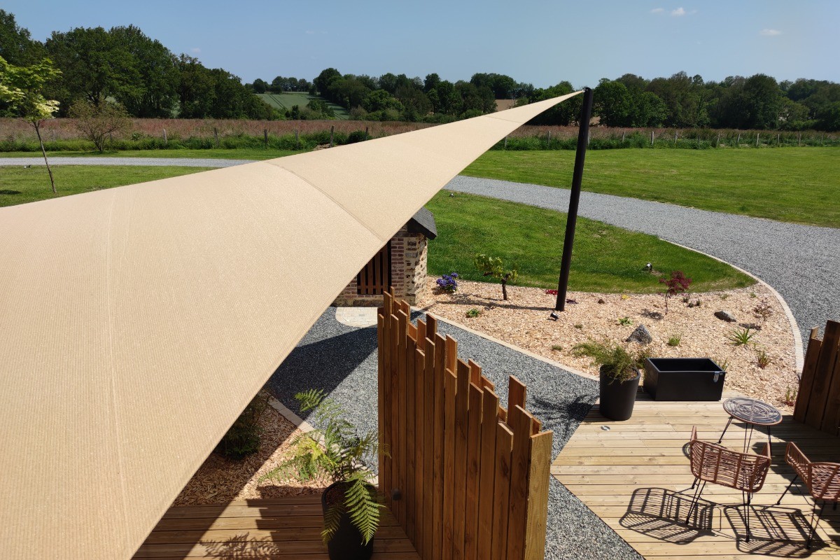 Vue pleine nature et vue sur la terrasse depuis le coin salon de la suite Izoë