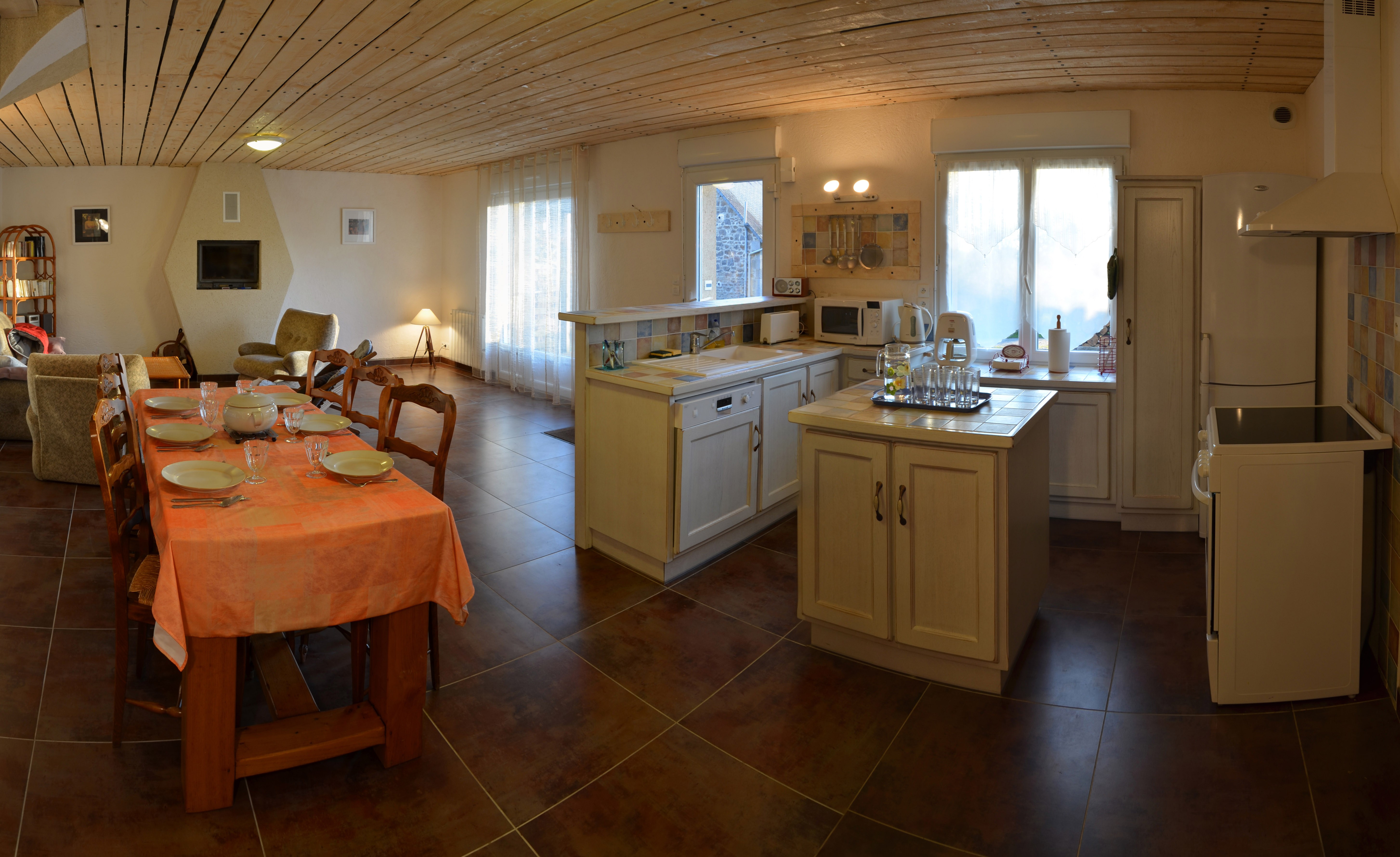 Grande pièce de vie au RDC avec cuisine, séjour et salon. Poêle à bois.