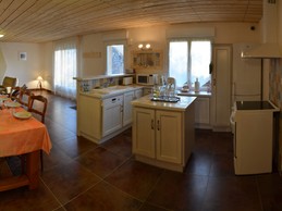 Grande pièce de vie au RDC avec cuisine, séjour et salon. Poêle à bois.