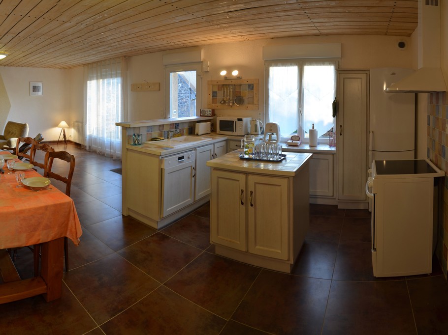 Grande pièce de vie au RDC avec cuisine, séjour et salon. Poêle à bois.