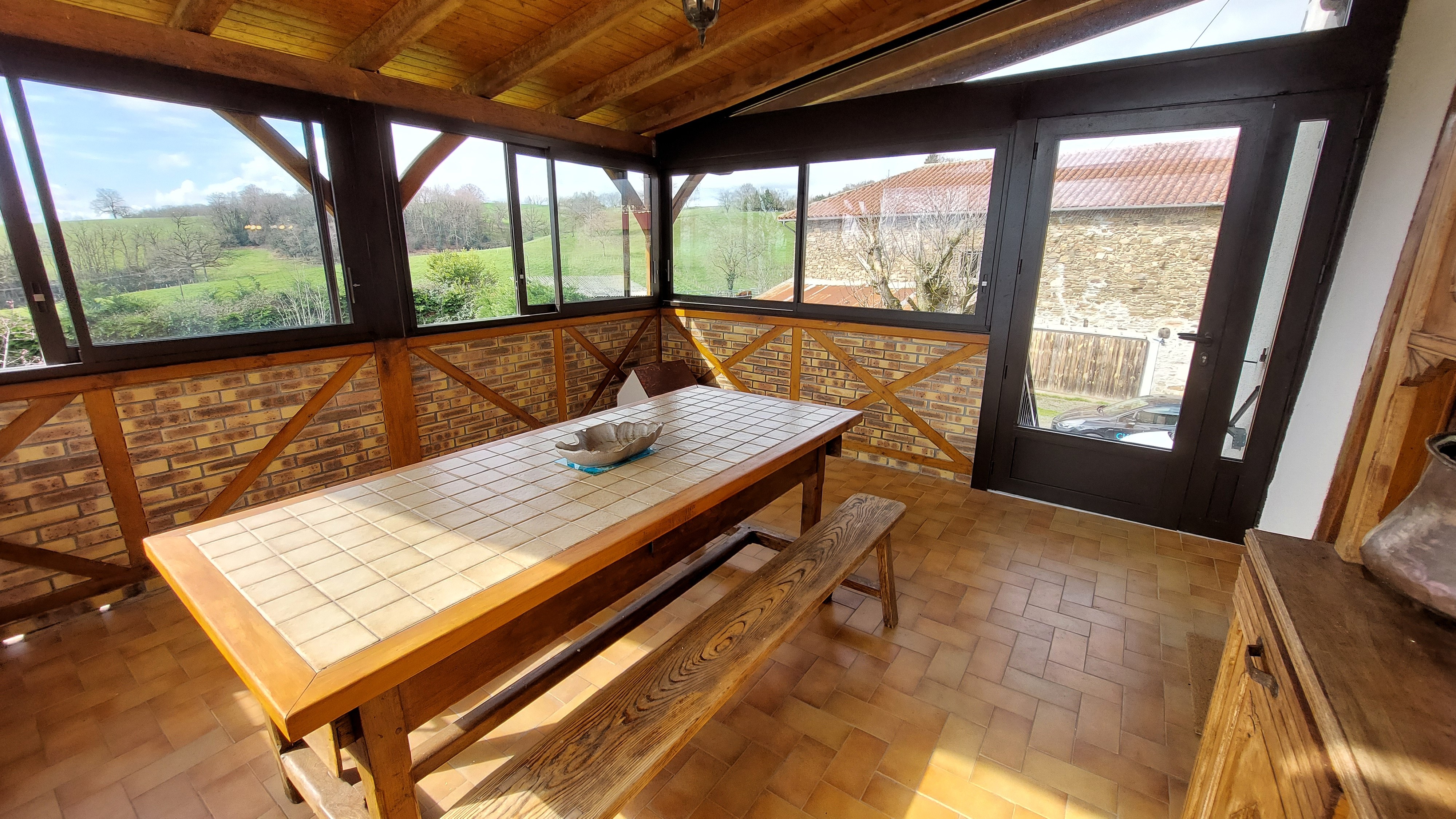 Veranda with large table and views of the Cantal countryside