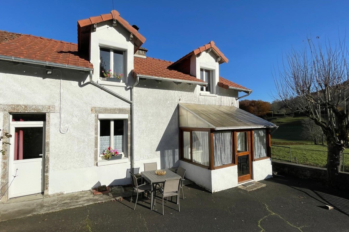 Façade de la maison avec deuxième terrasse aménagée dans une cour clôturée, parfaite pour profiter d’un espace sécurisé