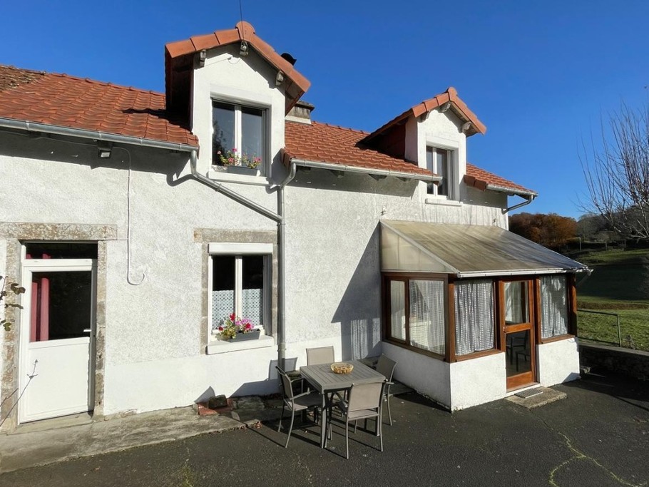 Façade de la maison avec deuxième terrasse aménagée dans une cour clôturée, parfaite pour profiter d’un espace sécurisé