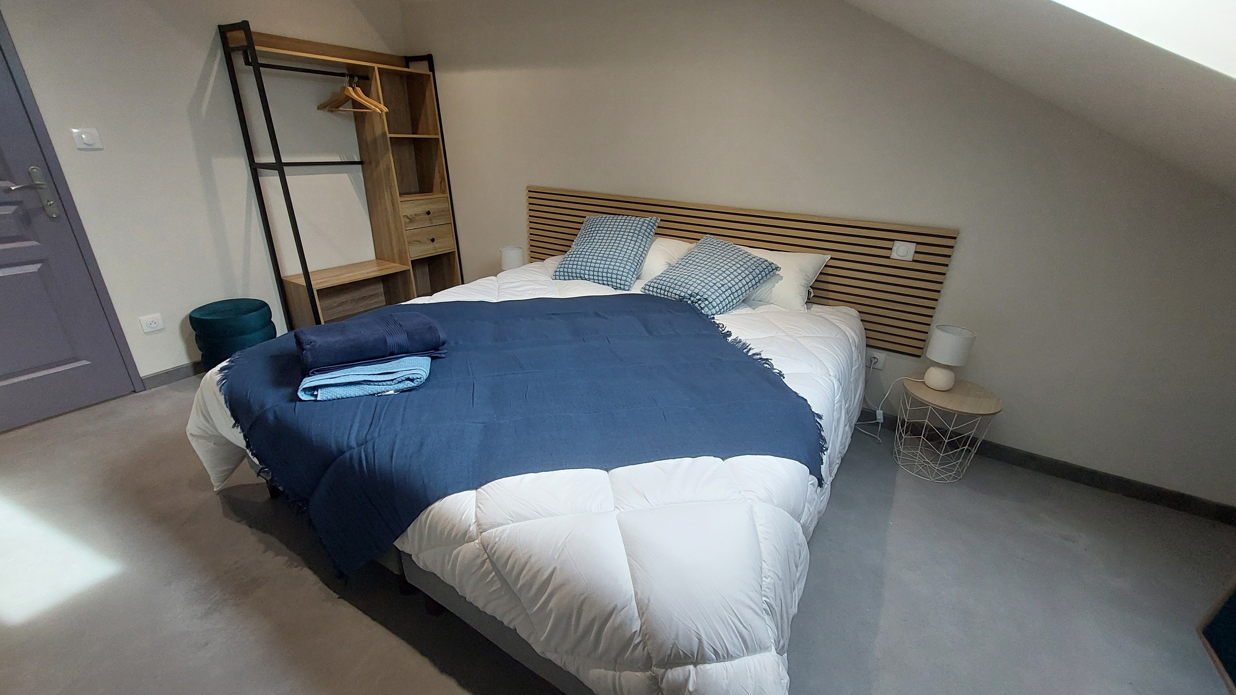Chambre bleue du gîte avec lit double modulable, linge de lit soigné et décoration élégante