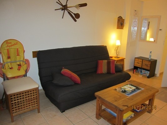 Coin salon avec un couchage clic clac. (Chaise haute à disposition)