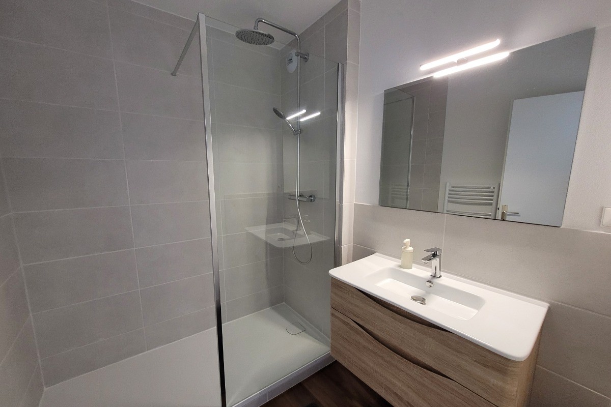 Salle de bain avec meuble ( sèche cheveux dans tiroir) et douche