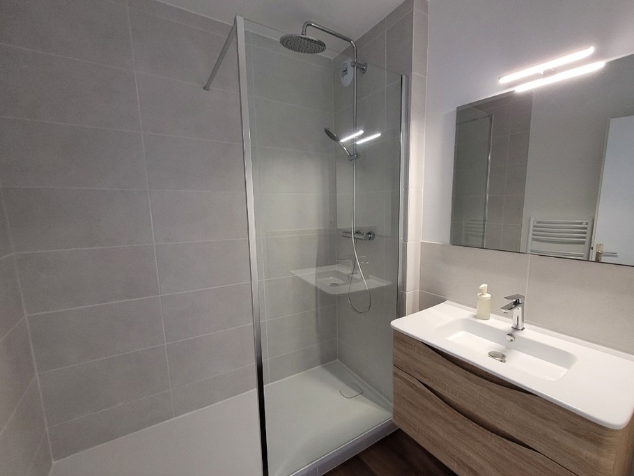 Salle de bain avec meuble ( sèche cheveux dans tiroir) et douche