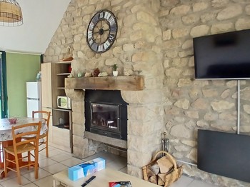 Etang de Farges, Saint Germain près Herment, Chalet vert - Pièce de vie avec cheminée et canapé convertible dans le salon