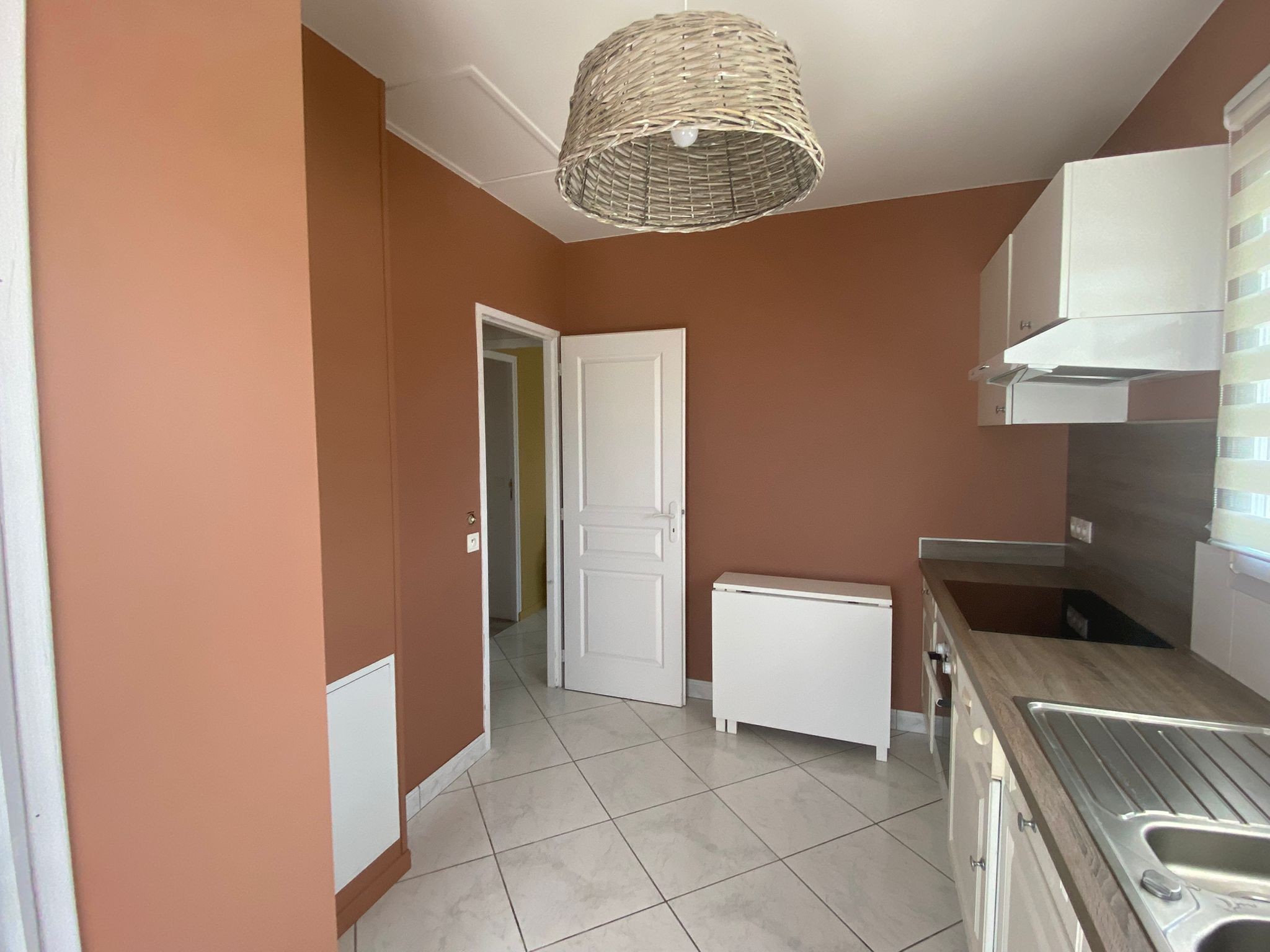 Cuisine équipée avec coin repas (table pliante). Porte communicante avec salon et couloir d'accès à la salle d'eau et la chambre
