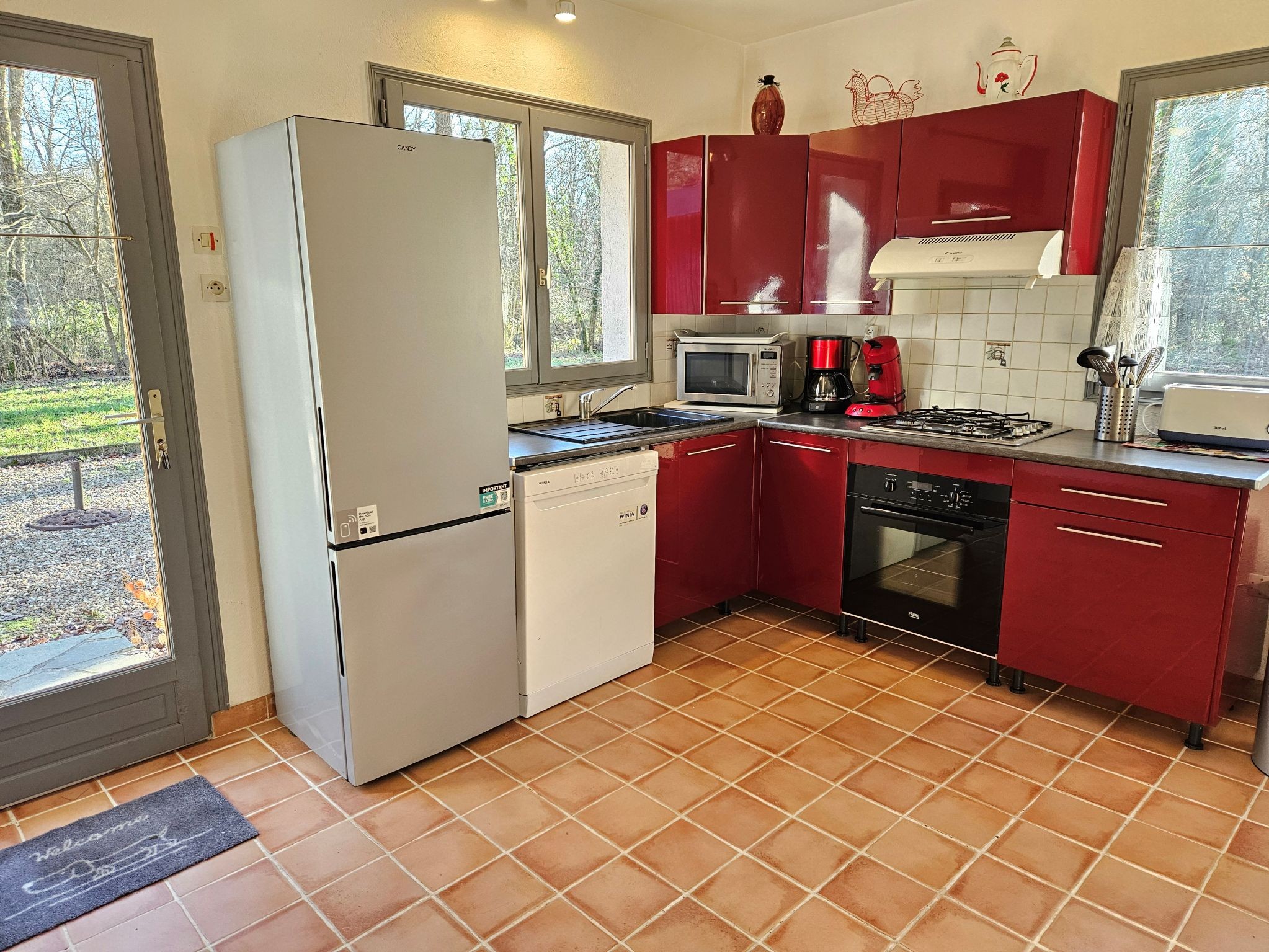 La cuisine aménagée avec la porte qui donne sur la terrasse à l'arrière du gite à Amboise