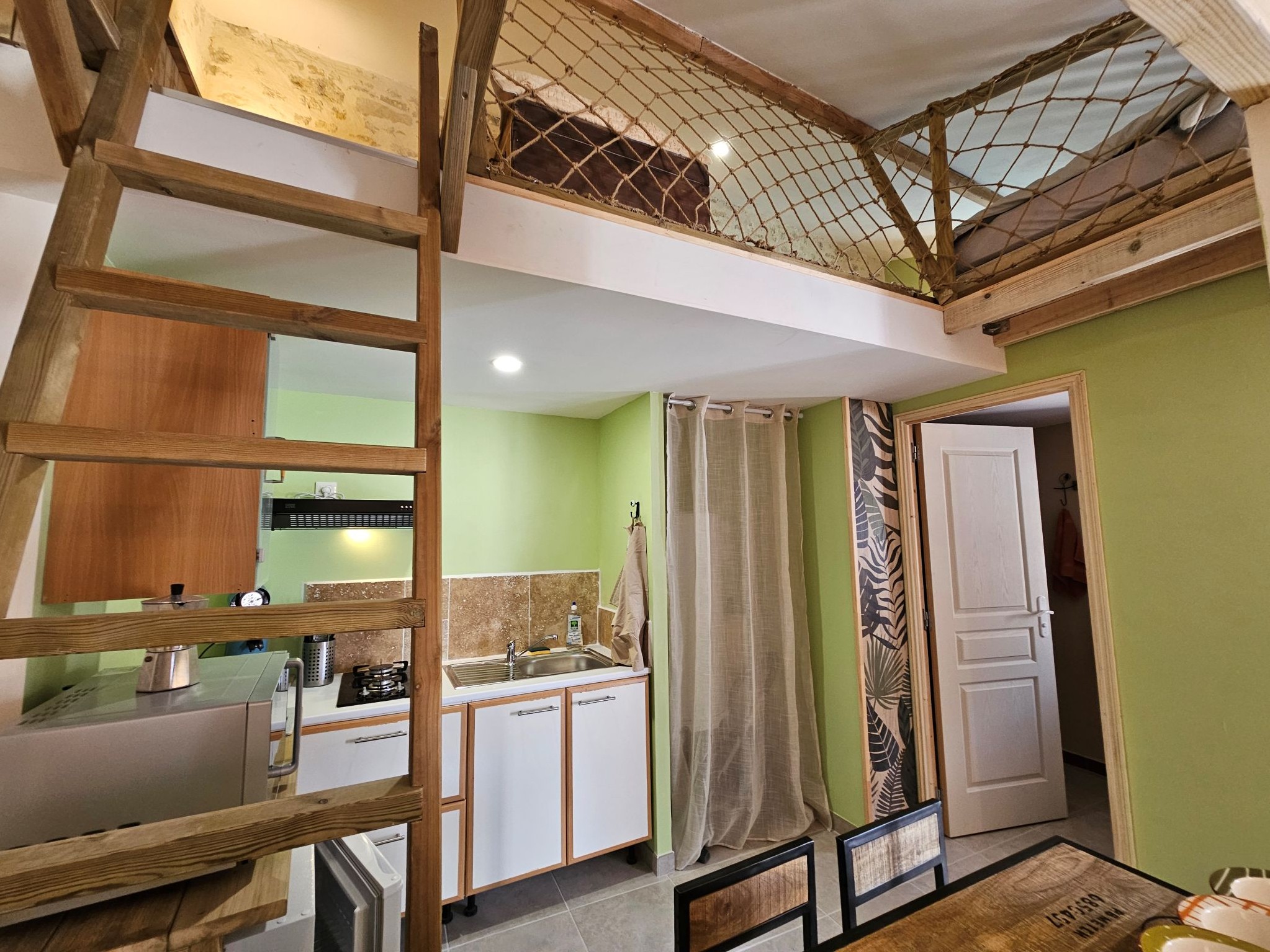 Echelle pour accéder aux lits une place et espace de jeux, et derrière la porte, accès à la salle d'eau