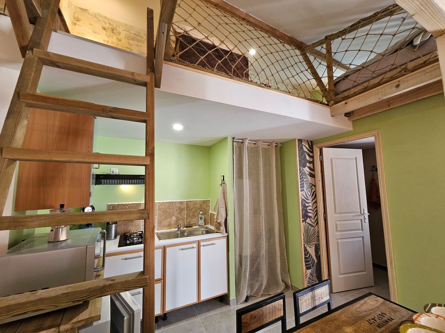 Echelle pour accéder aux lits une place et espace de jeux, et derrière la porte, accès à la salle d'eau