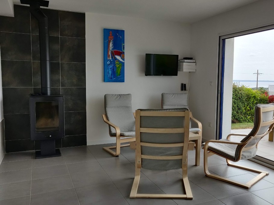 Salon avec poêle à bois vue mer