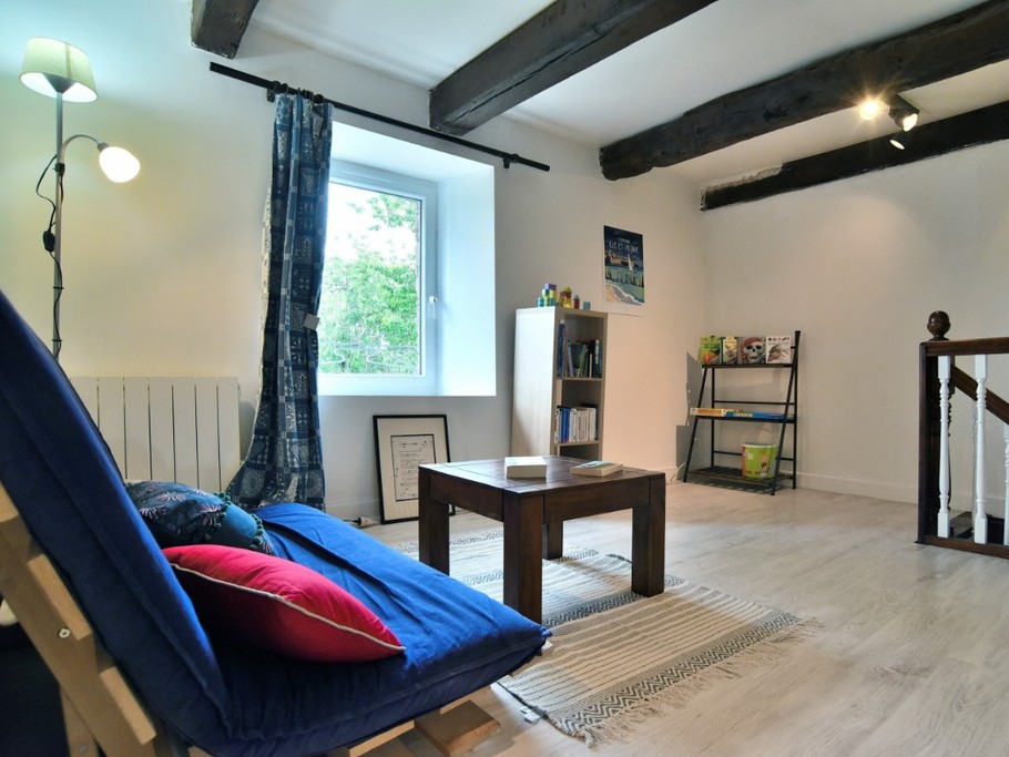 Coin détente à l'étage avec jeux, bibliothèque, canapé.